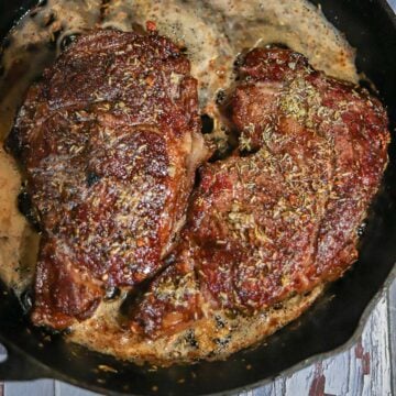 steaks being grilled in a pan