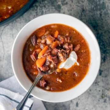 bean and ham soup in a white bowl