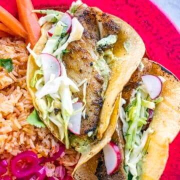 blackened fish tacos on a red plate